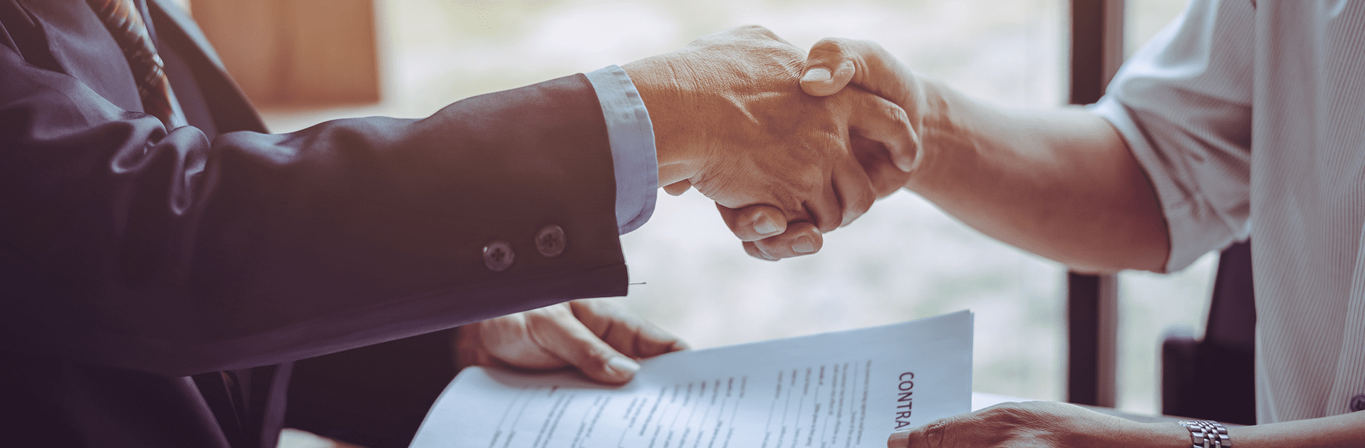 People shaking hands over a contract